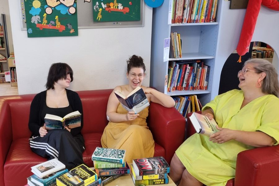 die drei Damen sitzen auf Sofas, jede ein Buch in der Hand