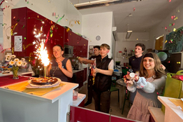 Die Jugendlichen feiern mit Konfetti und einer Torte mit Spritzkerze