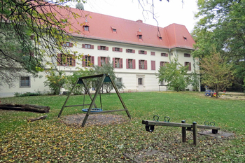 Kindergarten Tribuswinkel Schloss, der Garten mit Wippe und Schaukeln.