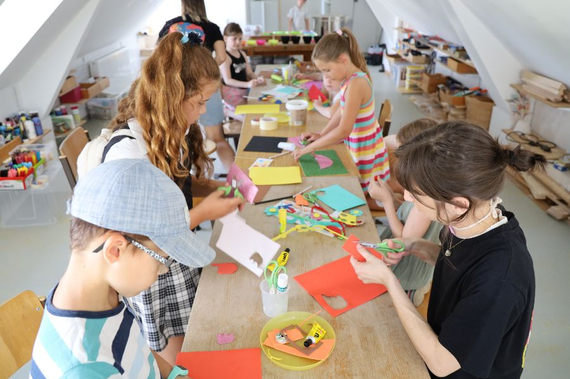 Einige Kinder basteln mit buntem Papier