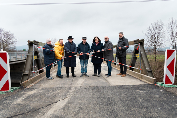 Die Brücke im Hintergrund, davor Edmund Kassecker vom Siedlerverband, Markus Bauer vom Bauamt, GR Franz Gartner, STR Erwin Mücke, Bürgermeisterin Sabrina Divoky, GR Josef Riesner, Stadtamtsdirektor Markus Tod