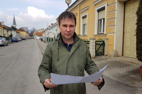 Traiskirchens Bürgermeister Andreas Babler auf der Straße mit einem Bauplan in der Hand.