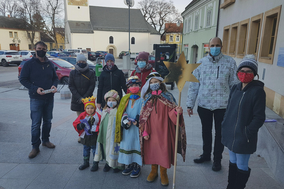 Eine Gruppe Sternsinger besuchen Bgm. Andreas Babler vor dem Rathaus.