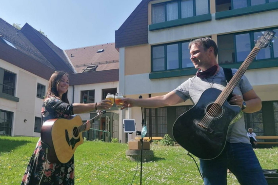 Mona Weinmeister und Bgm. Andreas Babler mit Gitarren vor dem Pensionistenwohnhaus.