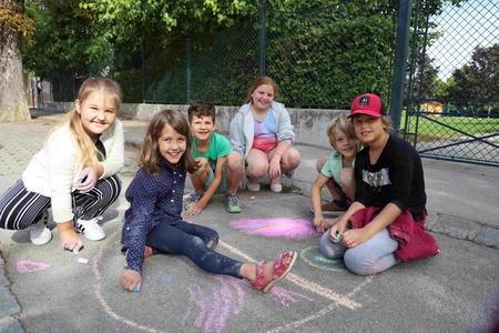 Volkschulkinder bemalen Straßen